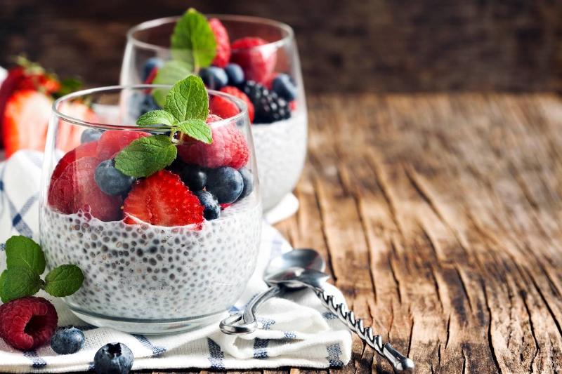 Cups of chia seed pudding are topped with berries and mint.