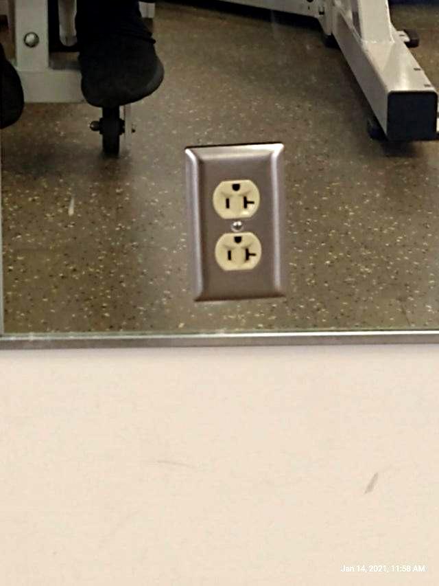 Crooked, upside down outlet that is placed on a mirror