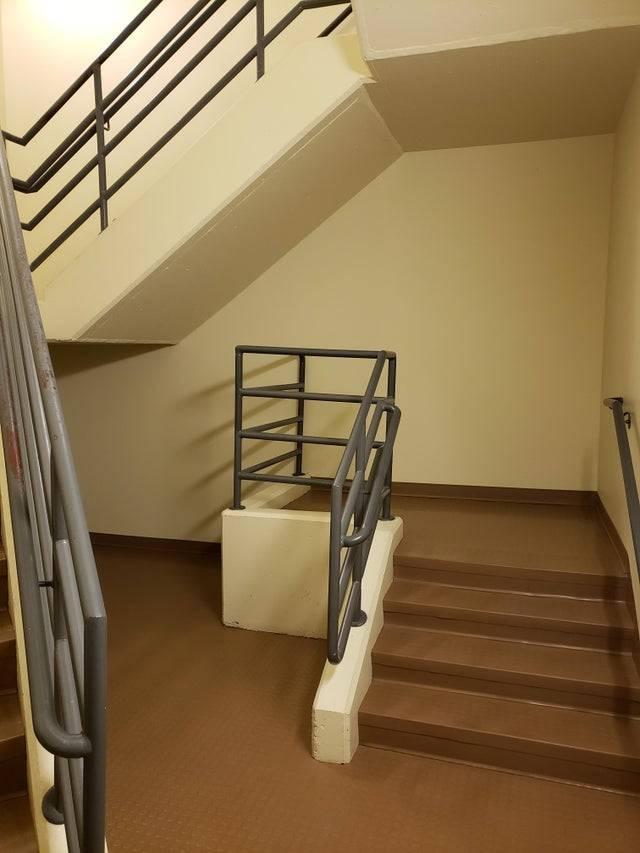 small, one flight staircase that leads to a wall next to a normal staircase