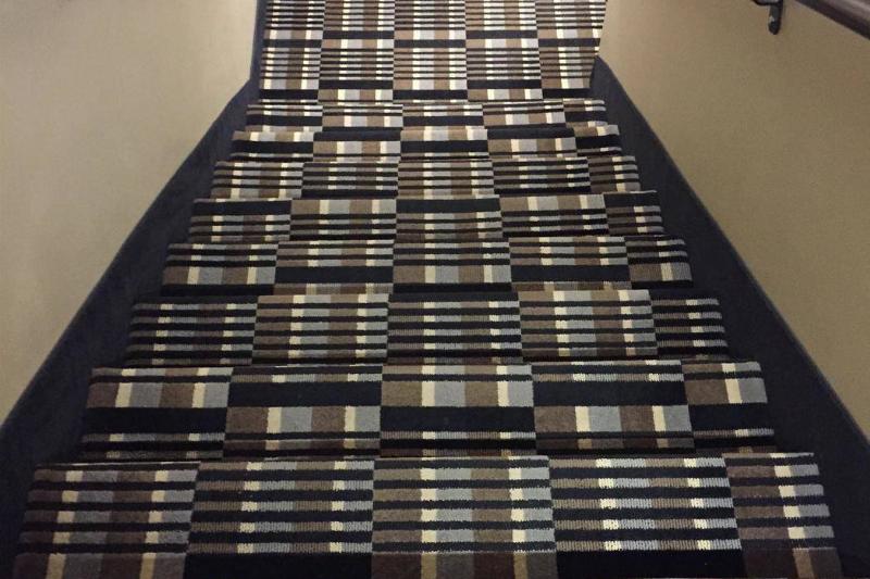 Stairs with a weird pattern on them that makes it hard to tell where the stairs actually are