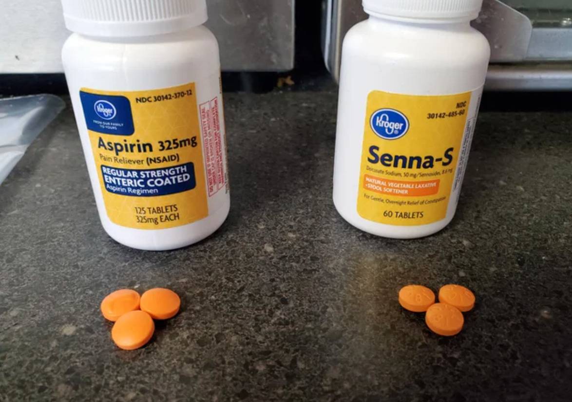 bottle of aspiring with orange pills and nearly identical bottle and pills, but it's a laxative