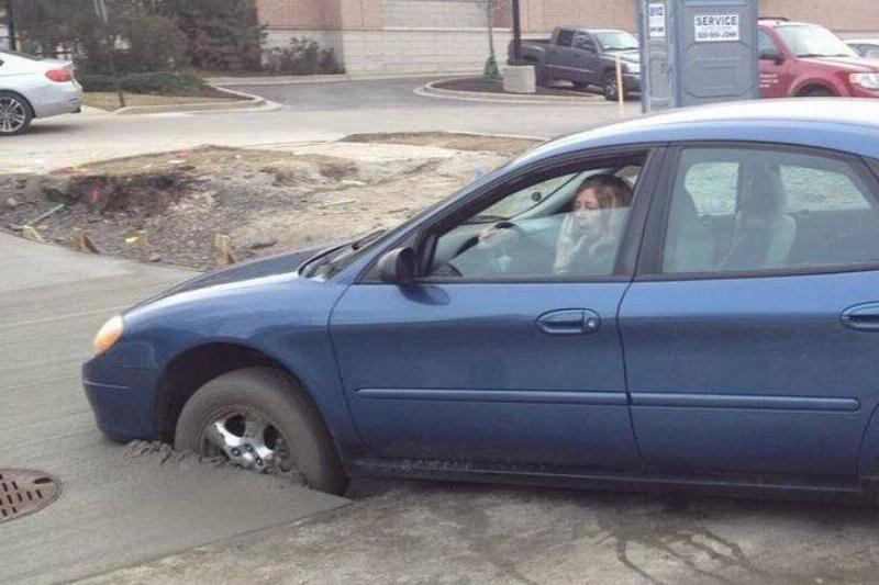 car with front wheels caught in wet concrete