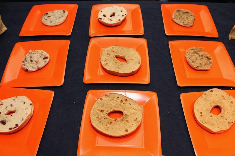 Orange square plates each hold half of a bagel.