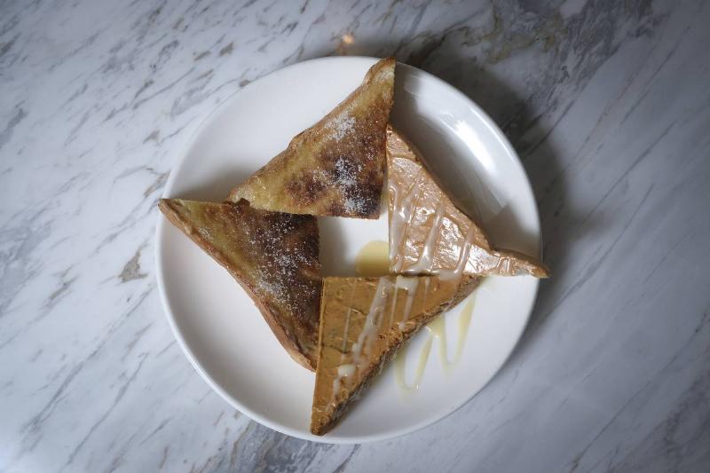 Triangle-shaped pieces of toast have peanut butter and condensed milk.