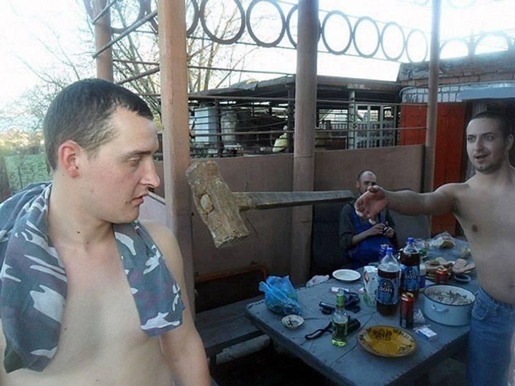 Photo taken moments after a man threw a hammer that looks like it is aimed at his friend