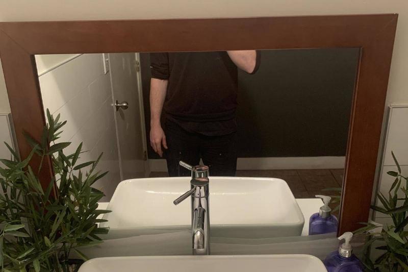 Mirror that is hung way too low on the bathroom wall so man can only see his bottom half while taking a selfie