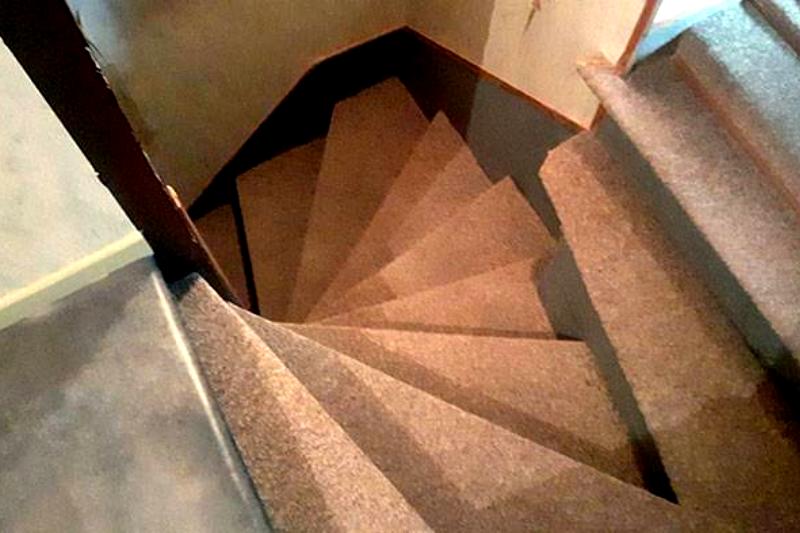 Spiral stairs intersect with a normal staircase - and they're the same colour