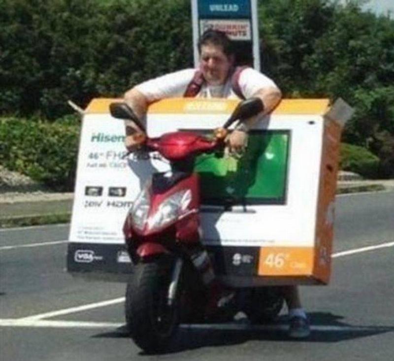 Person trying to transport oversized TV on a moped