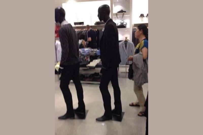 woman stands behind mannequins