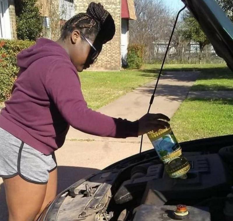 woman putting canola oil into her car