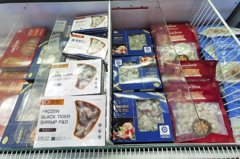 Bags and boxes of frozen seafood in a grocery store freezer