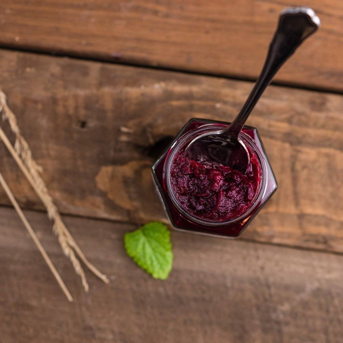 A spoon sticks out of a jam jar.