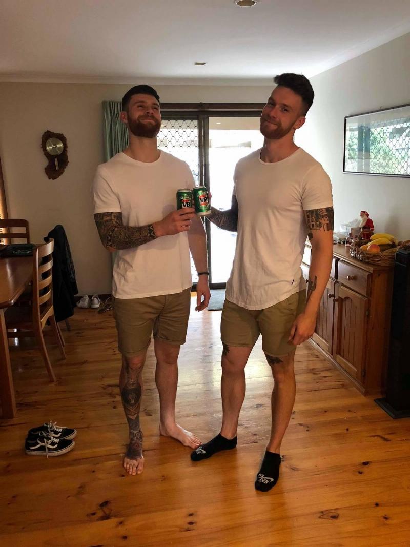 two brothers in same outfit cheering beers