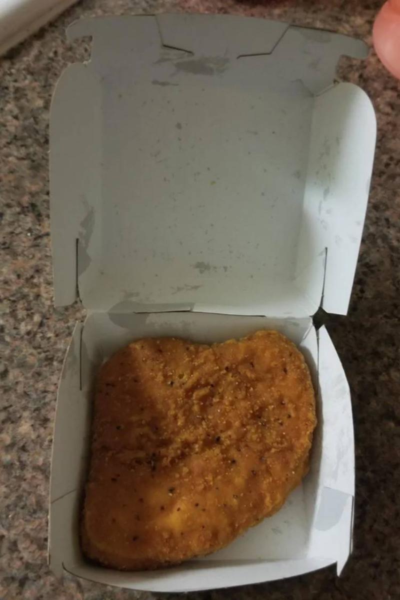 box with a singular large piece of breaded chicken
