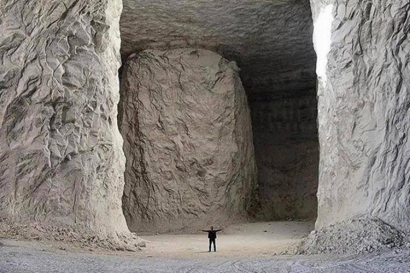  a man standing inside a huge salt mine