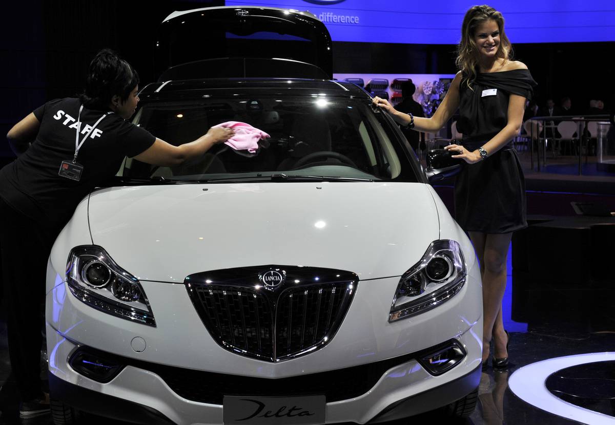 A woman clears a Lancia car during the p