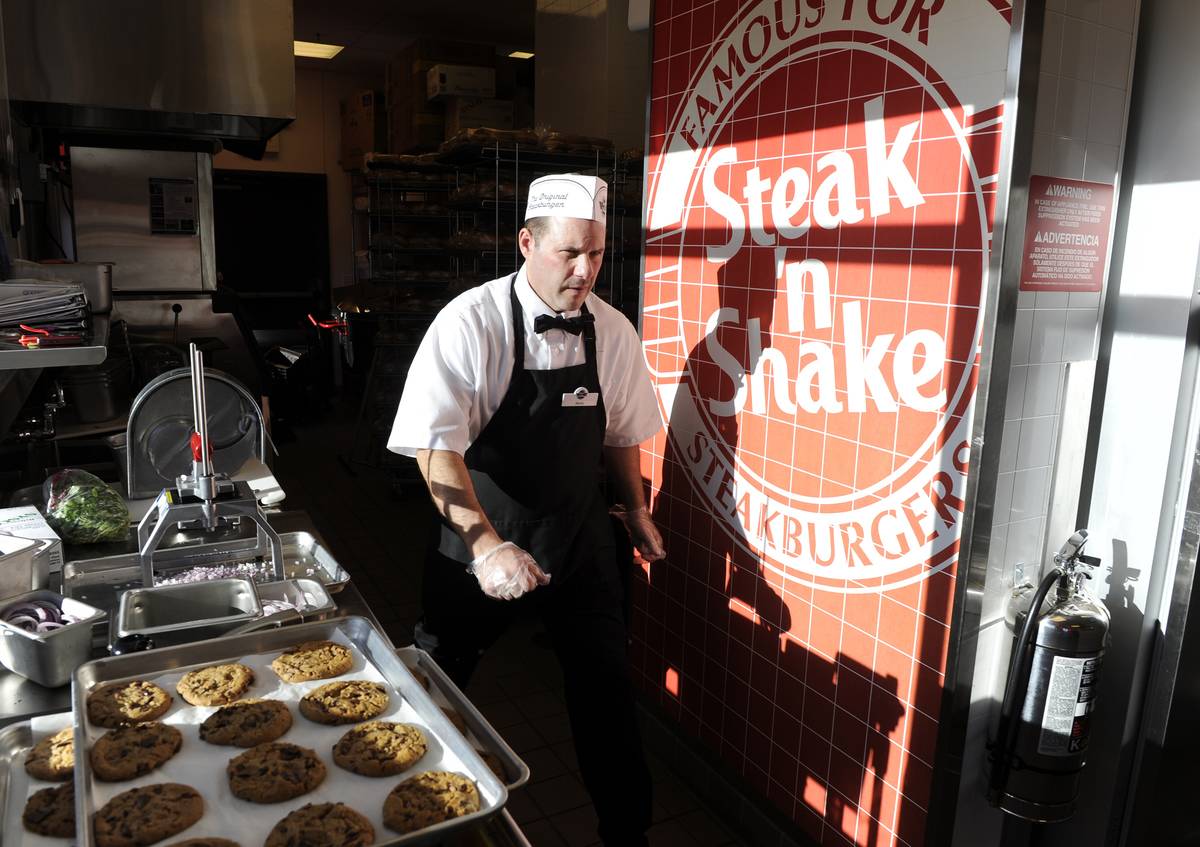 Steak'n Shake employee, Steve Jones, walks to his next task in the kitchen before the grand opening of the Steak'n Shake in Centennial Thursday morning. Andy Cross, The Denver Post