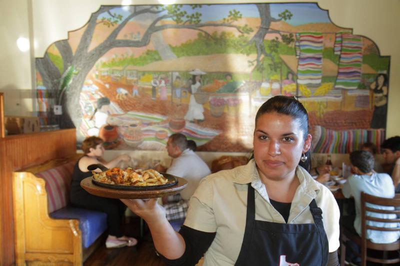 A waitress serving food at Casita Tejas Mexican Restaurant.