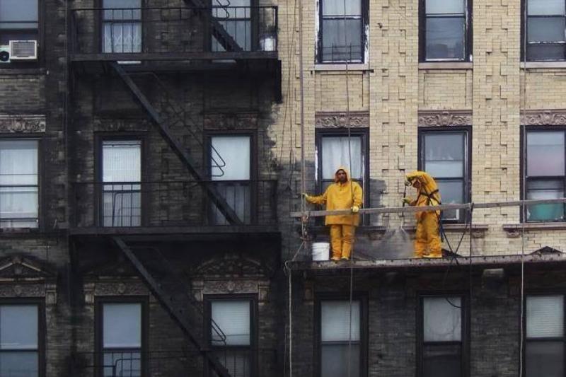 New York sanitation employees power wash a walk up apartment building