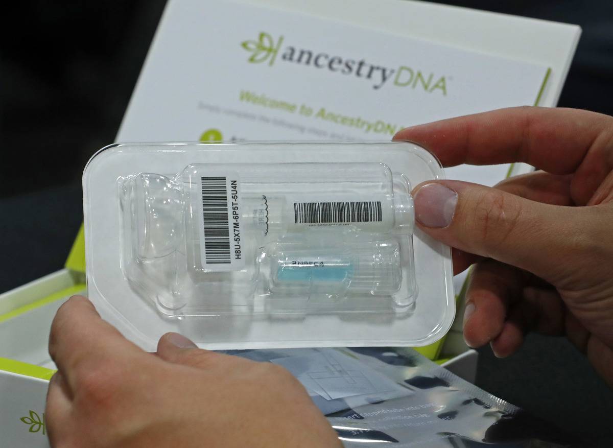 A person opens an at home DNA kit from ancestry.com.