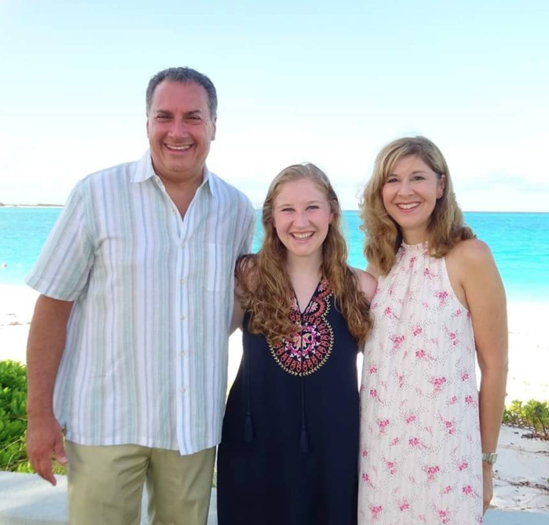 All three members of the Cartellone family are photographed in front of the beach.