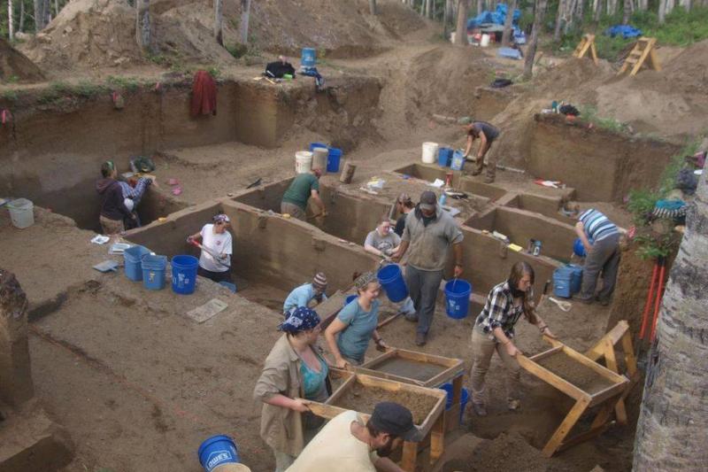 Archaeologists from Alaska work to dig up two human skeletons.