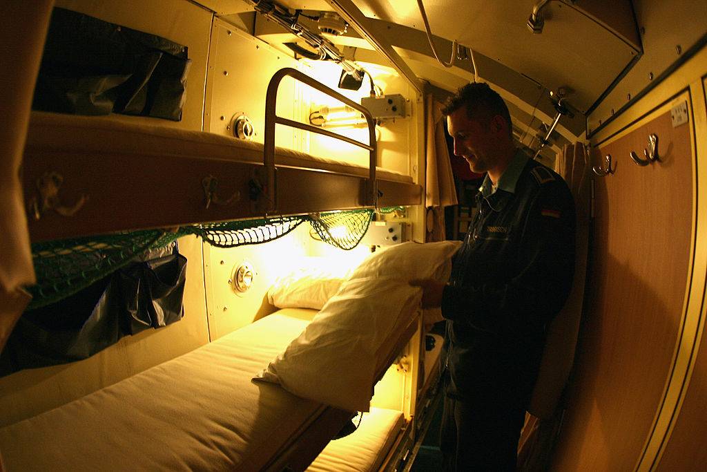 a soldier getting ready to sleep on a submarine