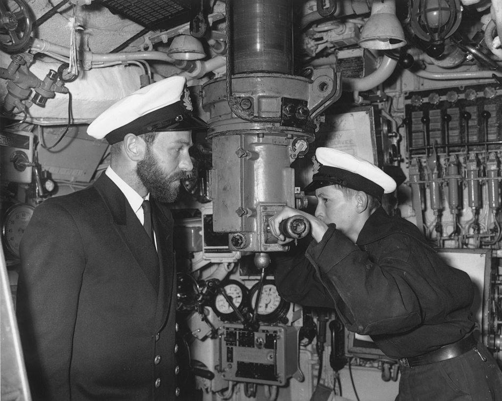 A sea cadet peers through the periscope of the submarine