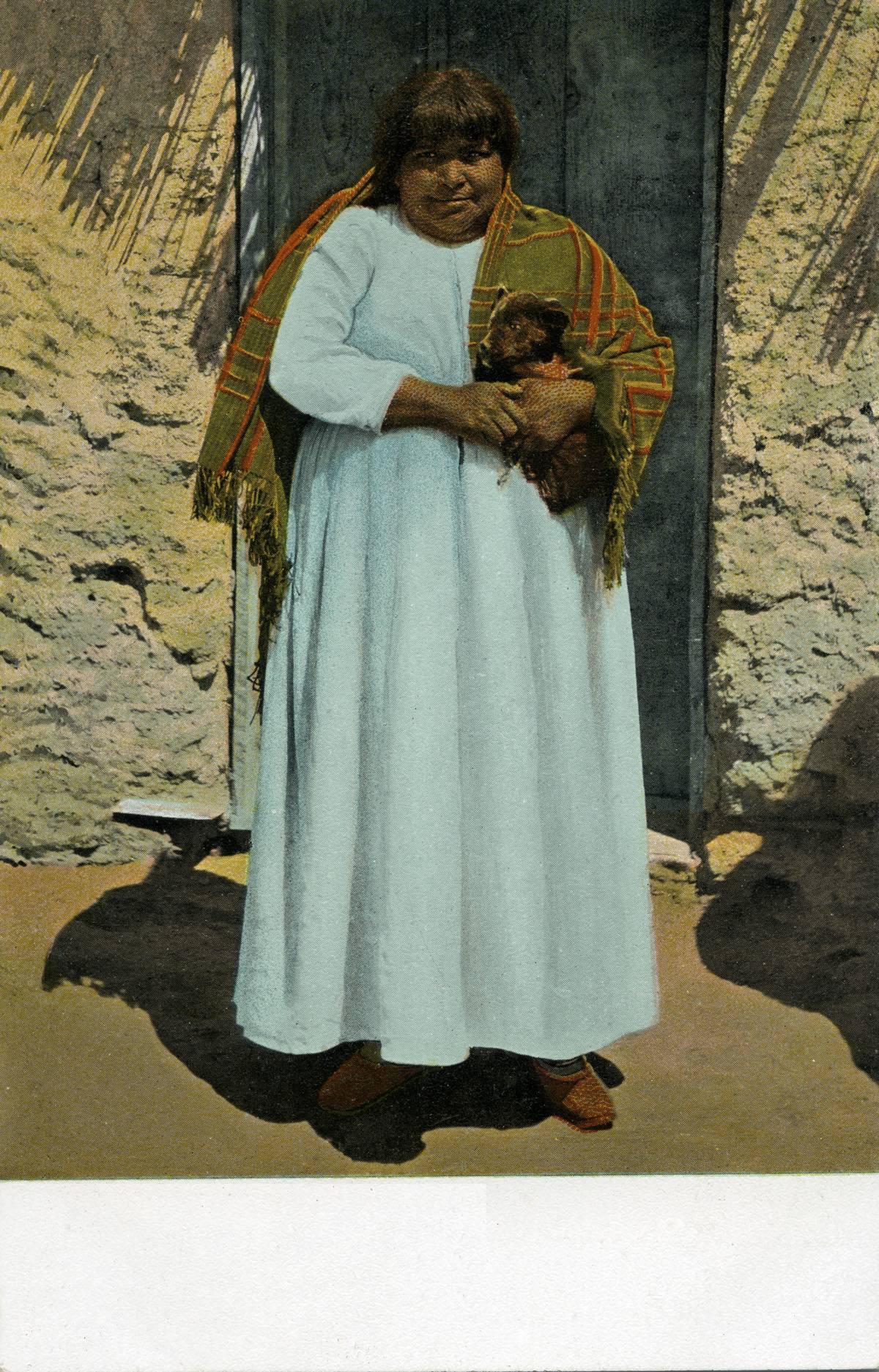 A Native American woman wears a long dress, 1913.