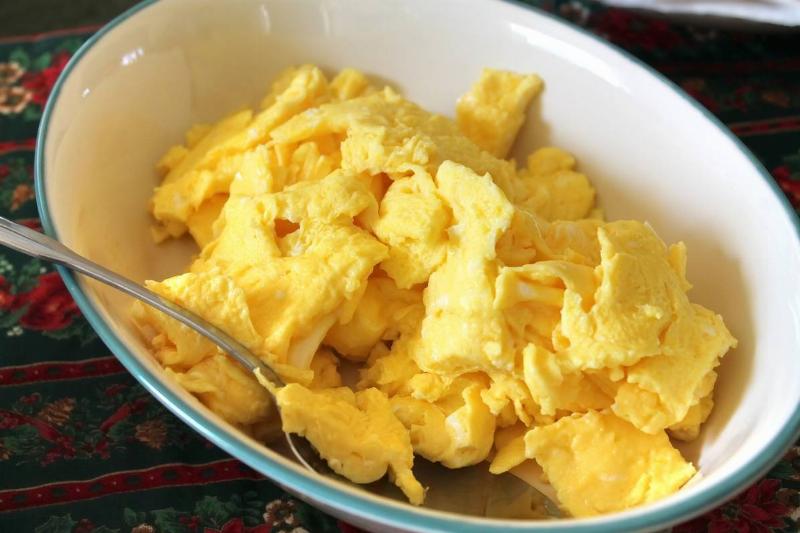 a bowl with scrambled eggs and a spoon