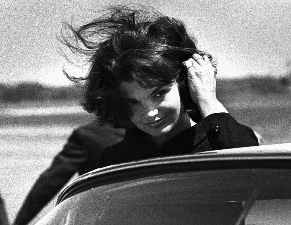 jackie kennedy brushes her wind-blown hair out of her eyes