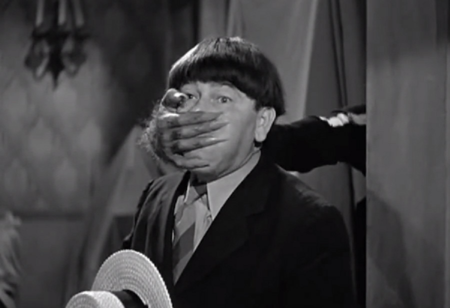 Moe with hand over mouth while filming Three Stooges 