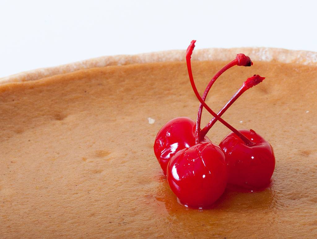 maraschino cherries on top of a pumpkin pie