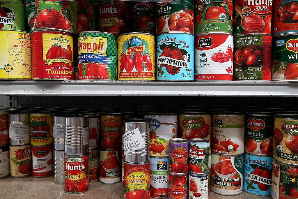 Canned tomatoes line the shelves of a pantry