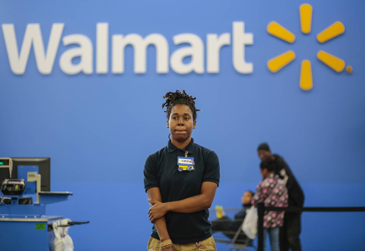 Christina Ford, stands by to help customers at the self checkout registers at a new Wal-Mart in Washington, DC