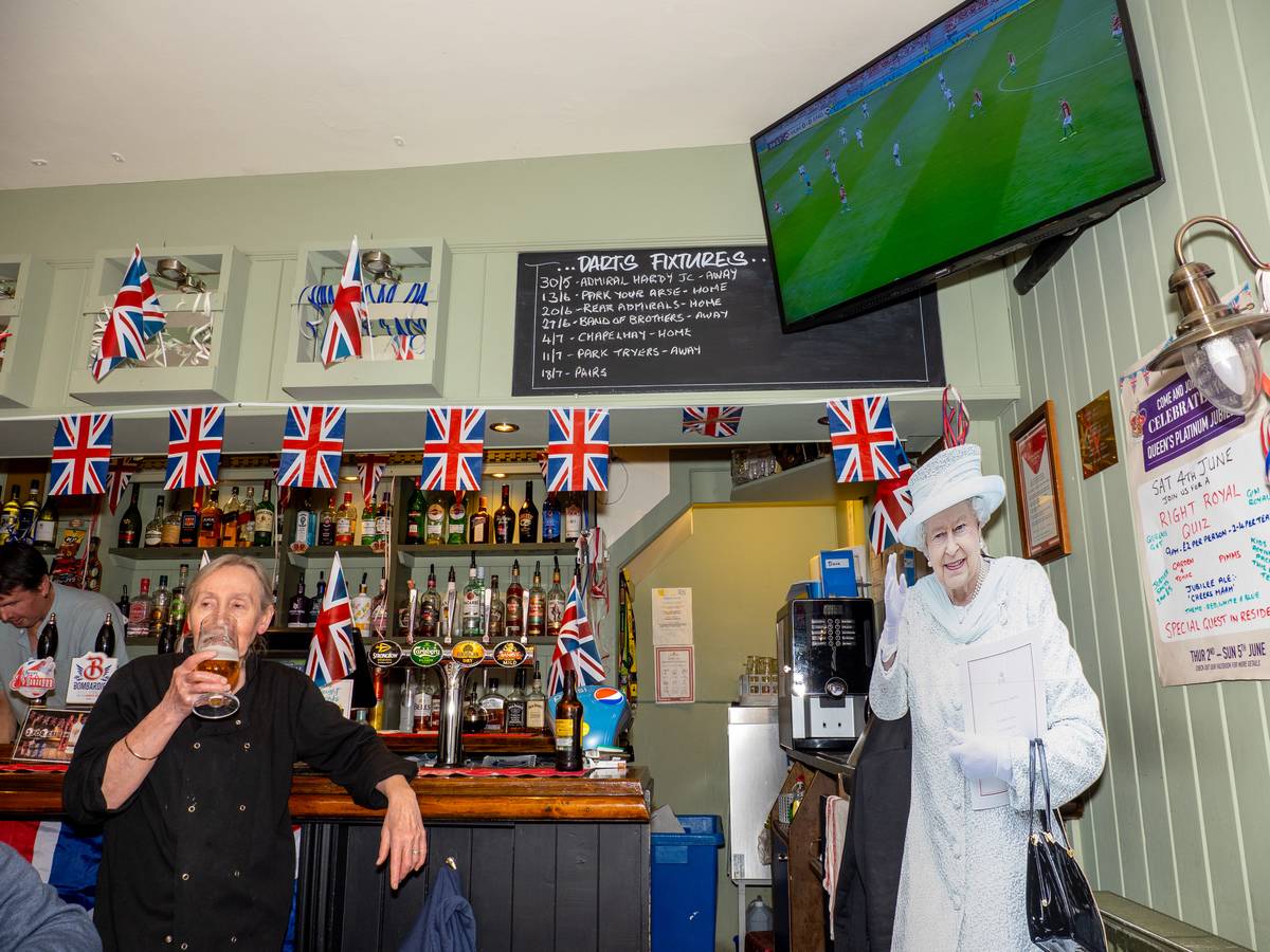  Visitors to a pub in Weymouth watch the Nations League Hungary versus England football match alongside a cut out of the Queen on June 04, 2022, in Weymouth, England
