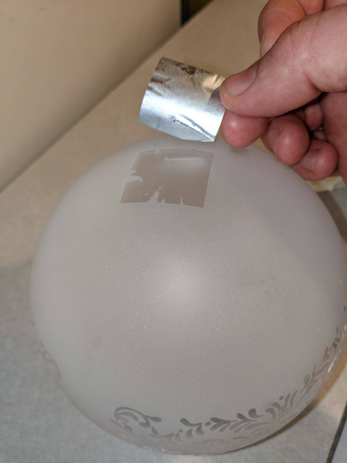 sticker on lamp being peeled
