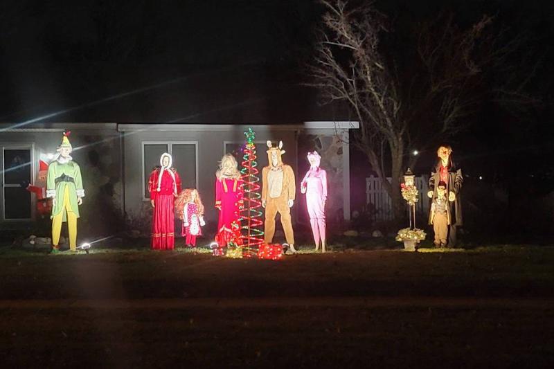 mannequins standing on lawn for Christmas display during dark night
