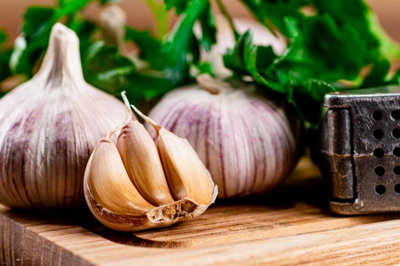 garlic-with-parsley-on-a-wooden-cutting-board-2022-01-12-02-16-16-utc