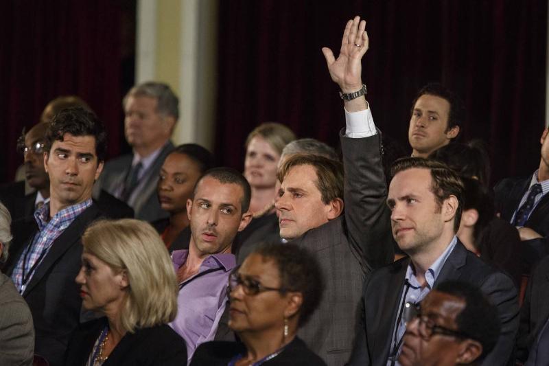 Steve Carell as Mark Baum raising hand at conference in The Big Short