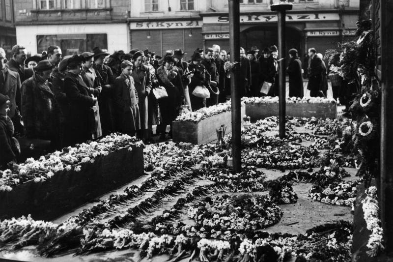 22nd March 1939:  Mourners surround the unknown soldiers tomb strewn with flowers in Prague, Czechoslovakia.