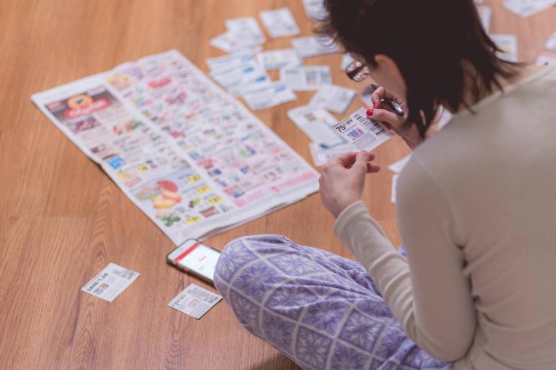 woman-at-home-clipping-coupons-from-news-paper-on-2022-11-15-06-43-03-utc