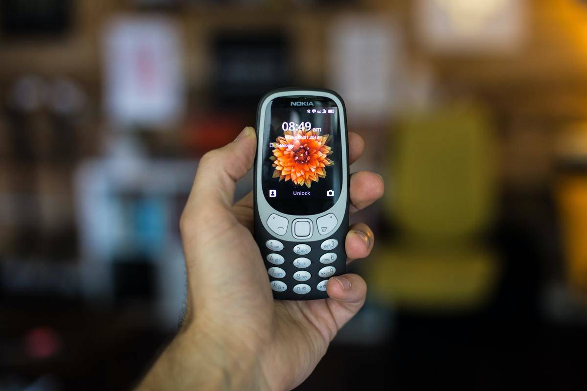Man's hand holding old Nokia cell phone