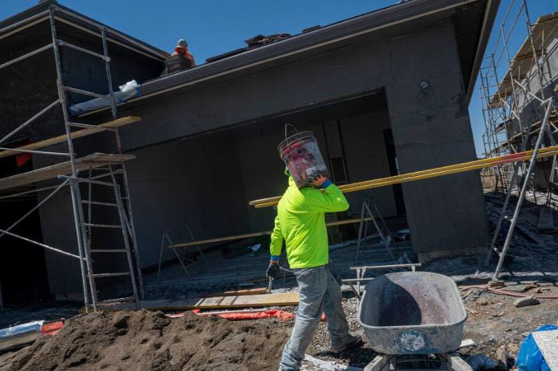 A contractor works on a house under construction A contractor works on a house under construction