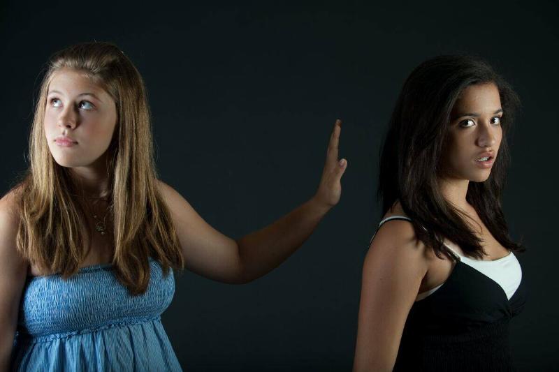 girl dismisses other girl with hand