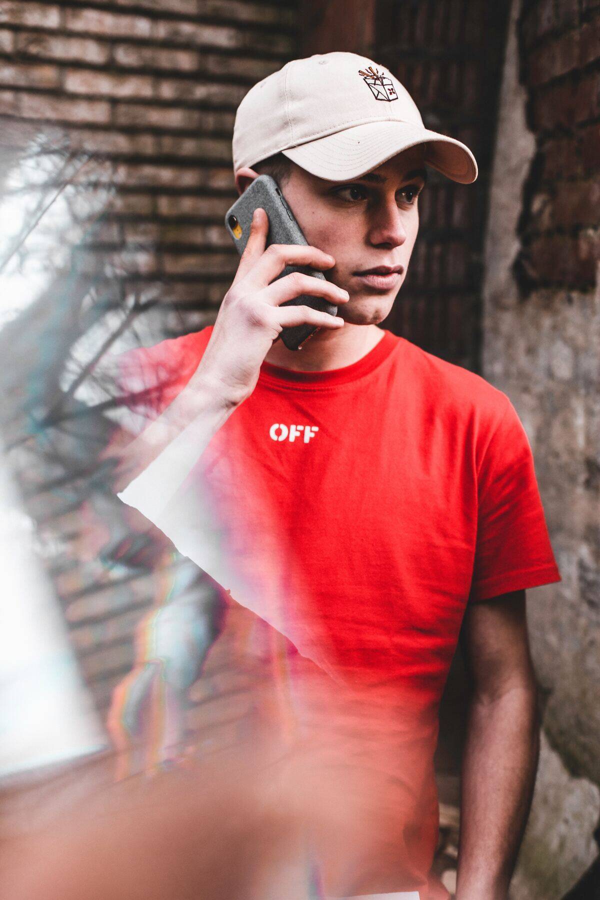 man in baseball cap talking on phone with serious expression