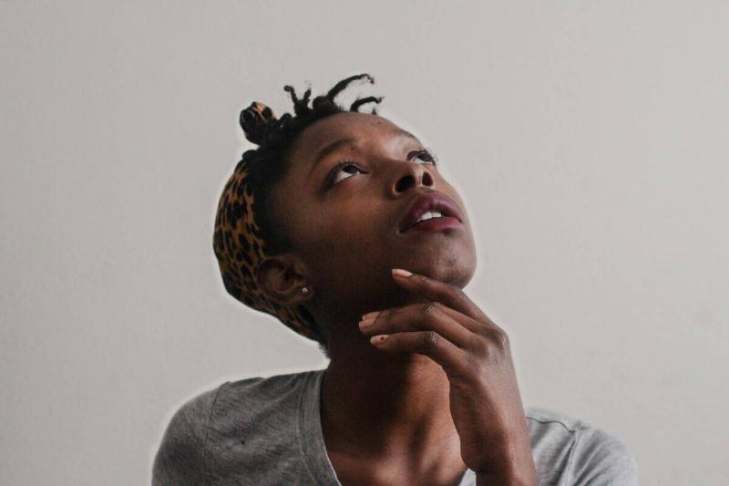 woman stroknig chin in thoughtful pose
