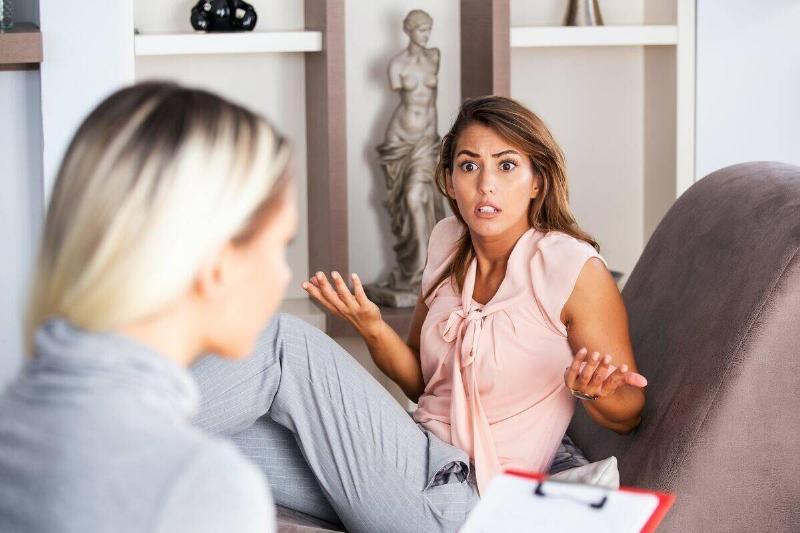 woman-having-animated-conversation-with-therapist-with-statue-in-background-65612