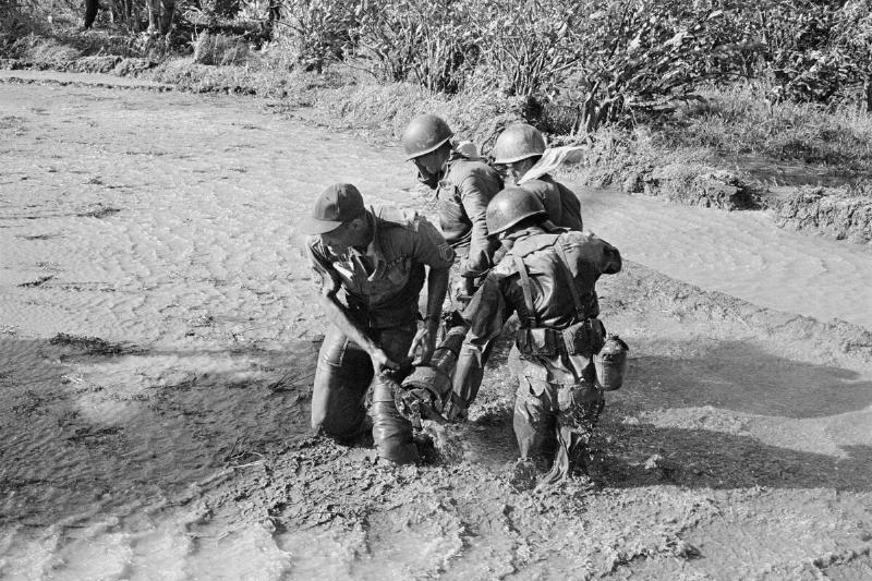Soldiers Carrying Recoiless Gun Across Stream