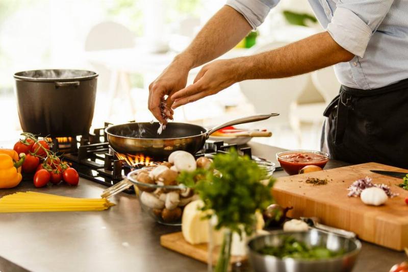 Person off-camera adding ingredients into a saucepan